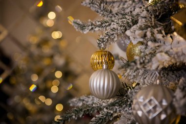 Geleneksel altın rengi oyuncaklarla süslenmiş Noel ağacı, parlak Noel çelengi