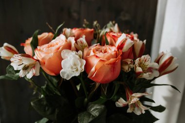 Siyah arka planda beyaz frezya tarzında beyaz frezya ile mercan renginde şakayık güllerinden oluşan büyük bir buket. karanlık aşk