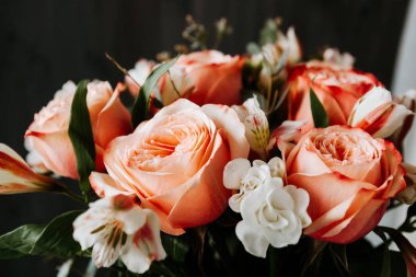 Siyah arka planda beyaz frezya tarzında beyaz frezya ile mercan renginde şakayık güllerinden oluşan büyük bir buket. karanlık aşk