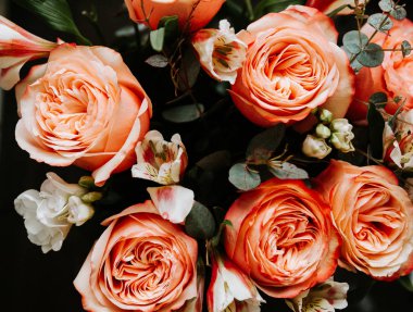 Siyah arka planda beyaz frezya tarzında beyaz frezya ile mercan renginde şakayık güllerinden oluşan büyük bir buket. karanlık aşk