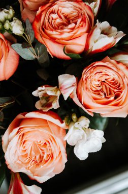 Siyah arka planda beyaz frezya tarzında beyaz frezya ile mercan renginde şakayık güllerinden oluşan büyük bir buket. karanlık aşk