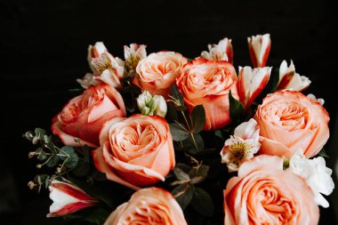 Siyah arka planda beyaz frezya tarzında beyaz frezya ile mercan renginde şakayık güllerinden oluşan büyük bir buket. karanlık aşk