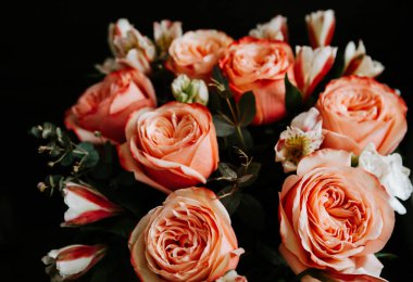 Siyah arka planda beyaz frezya tarzında beyaz frezya ile mercan renginde şakayık güllerinden oluşan büyük bir buket. karanlık aşk