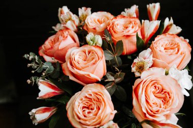 Siyah arka planda beyaz frezya tarzında beyaz frezya ile mercan renginde şakayık güllerinden oluşan büyük bir buket. karanlık aşk