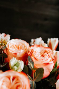 Siyah arka planda beyaz frezya tarzında beyaz frezya ile mercan renginde şakayık güllerinden oluşan büyük bir buket. karanlık aşk