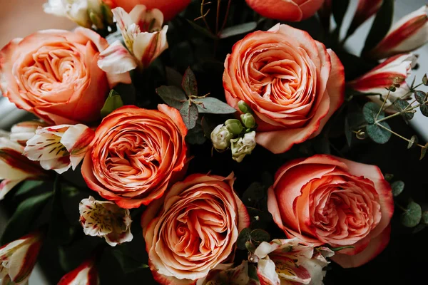 Siyah arka planda beyaz frezya tarzında beyaz frezya ile mercan renginde şakayık güllerinden oluşan büyük bir buket. karanlık aşk