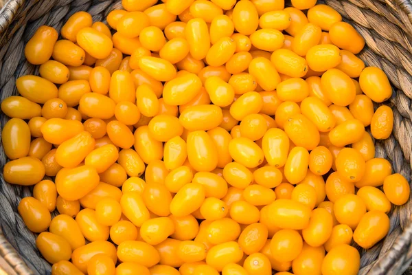Roșii galben cireșe într-un coș, fundal alimentar — Fotografie, imagine de stoc