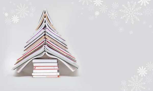 symbol Christmas tree from a colorful books on grey background