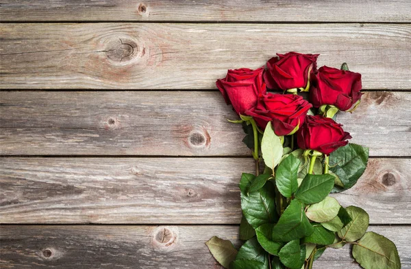 Buquê de rosas vermelhas sobre fundo de madeira. Dia dos Namorados fundo — Fotografia de Stock