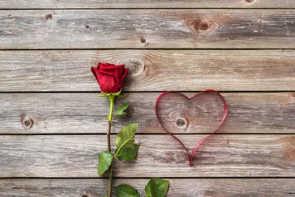 bir kırmızı kalpli ahşap arka plan üzerinde Şerit'ten yükseldi. Sevgiliye arka plan