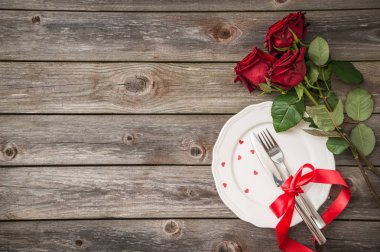 Beyaz bir tabak, gül ve şampanya bardağı romantik Tablo ayarı