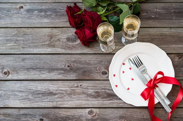 Beyaz bir tabak, gül ve şampanya bardağı romantik Tablo ayarı