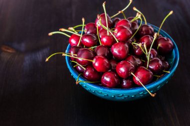 koyu arka plan üzerinde yeşil seramik kase kırmızı kiraz