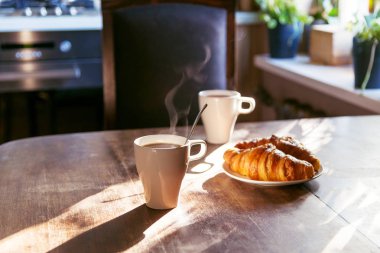 fincan sıcak kahve ve taze croiss olan iki kişi için kahvaltı