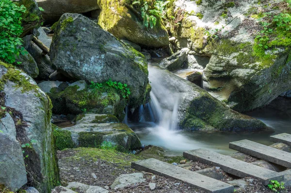 Büyük kayalarla çevrili küçük şelale