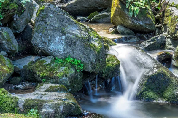 Büyük kayalarla çevrili küçük şelale