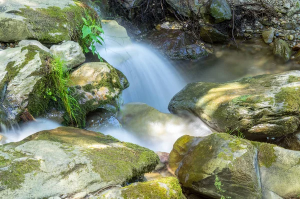 Büyük kayalarla çevrili küçük şelale