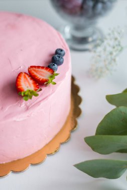 Çilek ve yabanmersinli ev yapımı pembe doğum günü pastası. Asgari düzeyde. Yiyecek konsepti