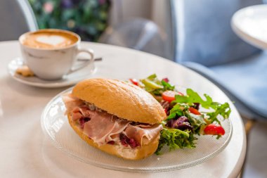 Kahvaltı ve öğle yemeği, sandviç ve kahve. Bir fincan kahve ve güzel Latte sanatı, yazı için yer. Yiyecek konsepti.