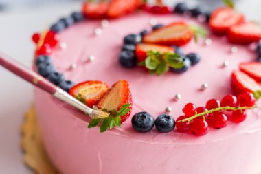 Pastayı fırçayla dekore eden şekerci. Doğum günü pastası. Altın çilek