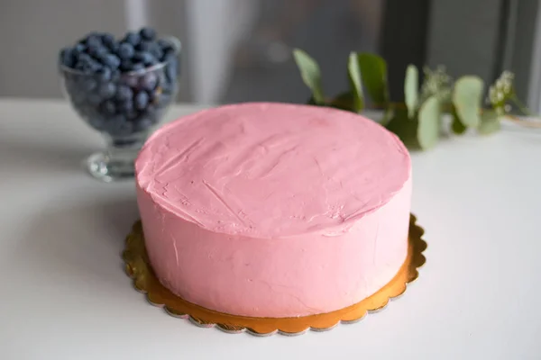 Chica cumpleaños crema queso pastel rosa. Simple pastel de maqueta con arándanos en la mesa blanca — Foto de Stock