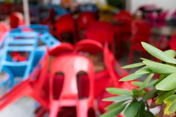 Wazig abstracte achtergrond van outdoor cafe. Kleurrijke tafels en stoelen in een café. Geel, blauw, rode kleuren. Buiten Europees restaurant in de stad — Stockfoto