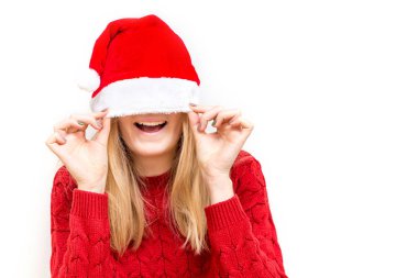 Örgü süveter ve Noel şapkası takmış gülümseyen güzel bir kız. Tatil konsepti. Duygusal yüz ifadesi.