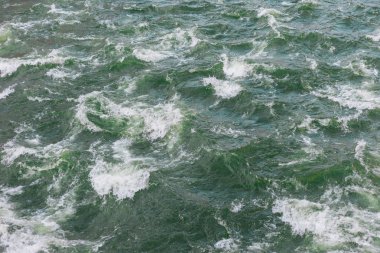 Dalgalı ve köpüklü yeşil deniz dokusu. Arka plan için soyut sıçrama turkuvaz deniz suyu