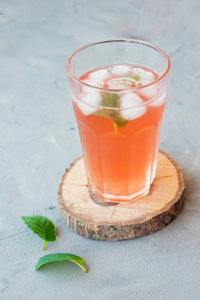 Copo de suco de frutas vermelhas frescas com gelo e hortelã no fundo de pedra cinza. Conceito alimentar — Fotografia de Stock