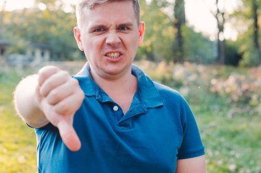 Adam, doğaya karşı ayakta dururken baş parmağını aşağı gösteriyor. Çok heyecanlıydı. İnsan Duyguları kavramı