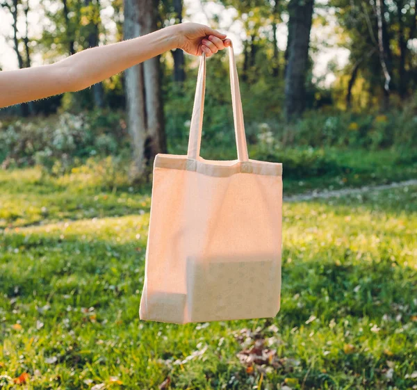 Mulher segurando lona sacola no fundo da natureza. Conceito ecológico. Ao ar livre — Fotografia de Stock