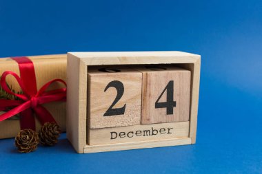 Kırmızı kurdeleli kahverengi hediye kutuları ve mavi modaya uygun arka planda köknar ağacı dalı. Projeler için şölen arkaplanı. Yılın renginde. Takvimdeki Noel arifesi randevusu. 24 Aralık
