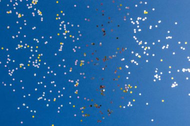 Mavi renkli arka planda gümüş parıltılar. Projeler için şölen arkaplanı. Düz yatış stili. Üst Manzara. Yılın rengi.