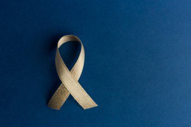 Hastalık kontrol konsepti. Koyu mavi arka planda altın kurdele, üst manzara, kopyalama alanı. Vaktinde araştırma ve hastalık önleme kolon hastalıkları, kronik yorgunluk sendromu kavramı