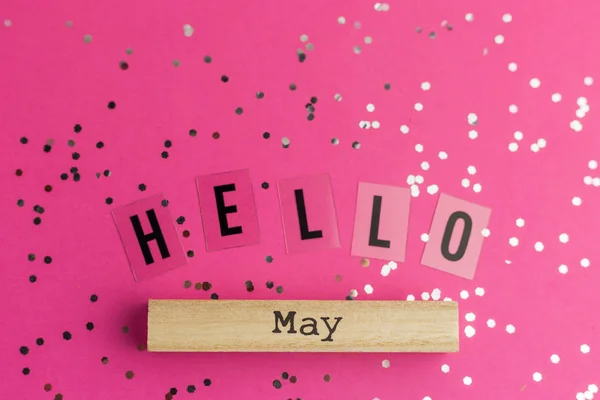 Labor Day. Hello May text on Pink background with multicolored confetti. Flat lay style. Top view. holiday or a birthday concept. International Workers Day