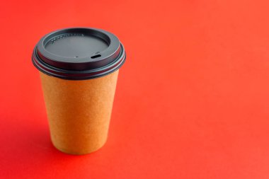 Kırmızı arkaplanlı ve fotokopi alanı olan paket içecekler için kağıt kahve fincanı. Kahverengi kağıt bardak.