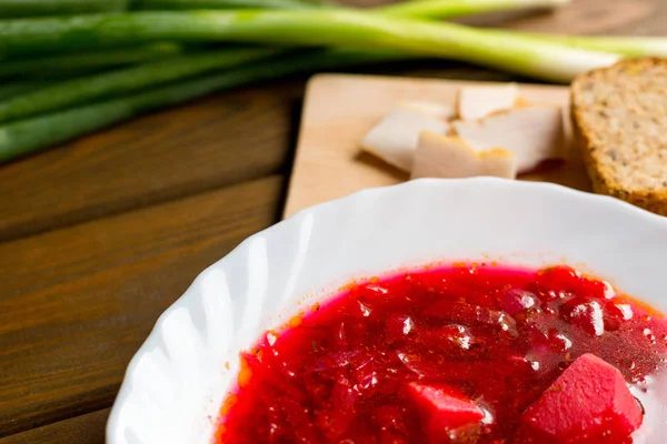 Sopa de beterraba tradicional ucraniana Borscht com pão, fatias de bacon e cebola na mesa de madeira, conceito de comida — Fotografia de Stock