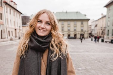 Sokakta yürüyen güzel bir genç turist kadın. Bahar moda kadın konsepti. Güzel bulutlu bir gün, eski kasaba