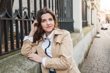 Şehir sokağındaki güzel genç kadın. Dışarıda yürüyen mutlu kız. Eski şehirde poz veren güzel bir kadının bahar portresi.