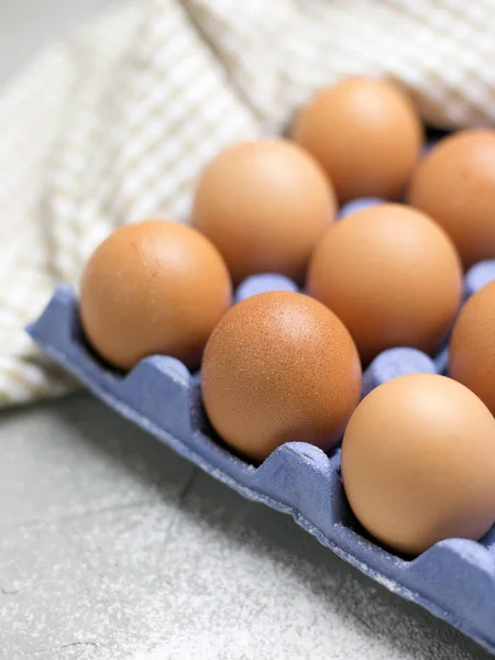 Chicken eggs in blue carton box on table