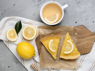 İki dilim limonlu turta, taştan arka planda yakın plan.