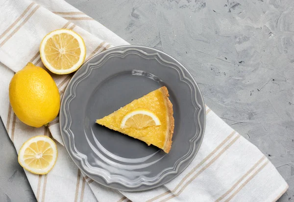 Plate with piece of tasty lemon pie on stone background, copy space
