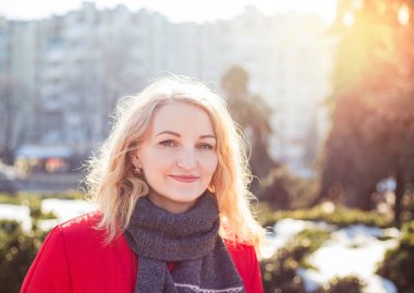 Gülümseyen kız kameraya bakıyor, açık havada güzel bir kadının portresini yakından çekiyor.