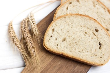 Tahtadaki taze ekmek ve buğday beyazı izole edilmiş.