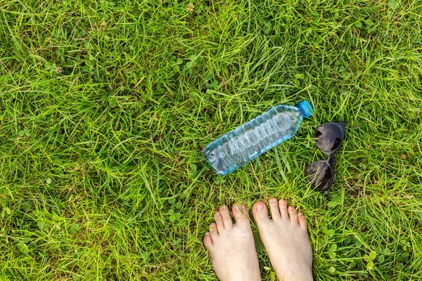 Plastic bottle with clear water in green grass