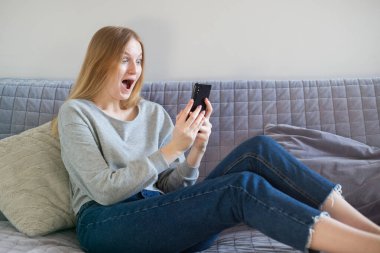 Telefonla selfie çeken bir kadın. Kız telefonla iletişim kuruyor. Mobil fotoğrafçılık. Teknoloji konsepti ve dijital aygıtlar.