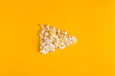 Sarı arka planda patlamış mısır. Düz pankart, üst manzara. Sinemaya gitmek için. Film izlemeyi severim..