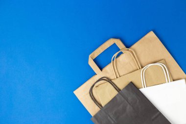 Üzerinde okaliptüs yaprakları olan beyaz ve siyah kağıt poşetler. Düz pankart, üst görünüm, kopyalama alanı, sıfır atık, plastiksiz eşyalar. Model Paketi