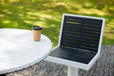 Kahve, çay ya da kokteyl içmek için kahve dükkanından bir kağıt bardak kahve alın ve gidin. Modelleme için, doğa geçmişi. Terasta bir masada iç.