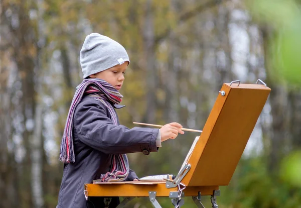 Молодой художник в осеннем лесу — стоковое фото